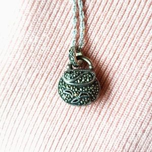 Purse-shaped pendant with opening top.